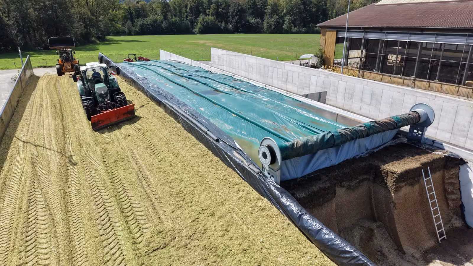 Einsilieren mit Traktor unter dem hochgefahrenen Abdecksystem